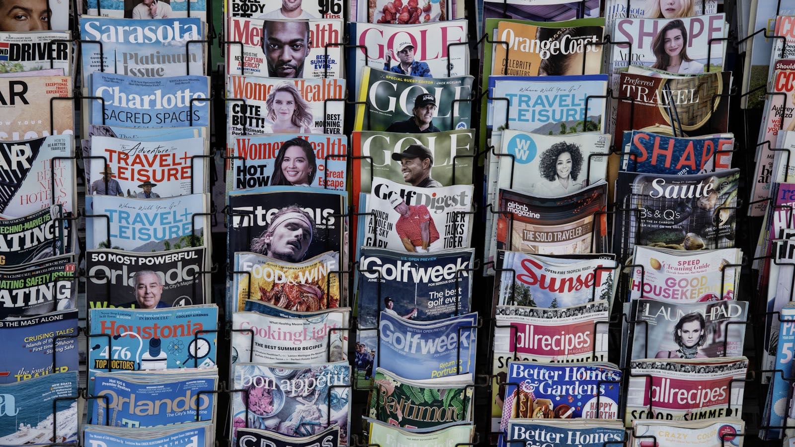 A newsstand rack packed with magazines competing for attention