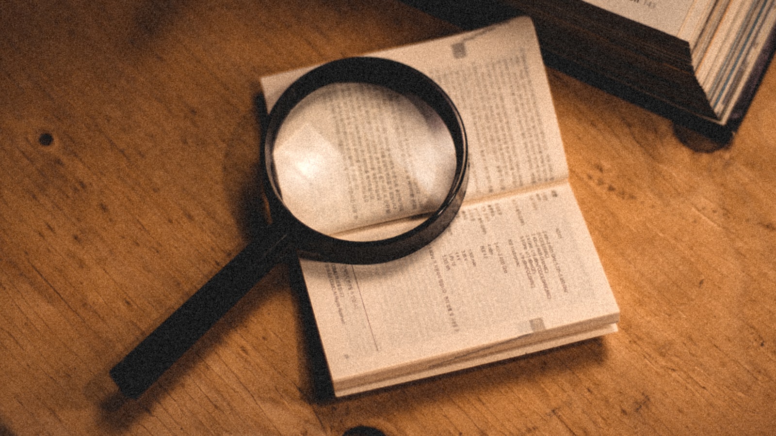 A magnifying glass resting on the pages of an open book
